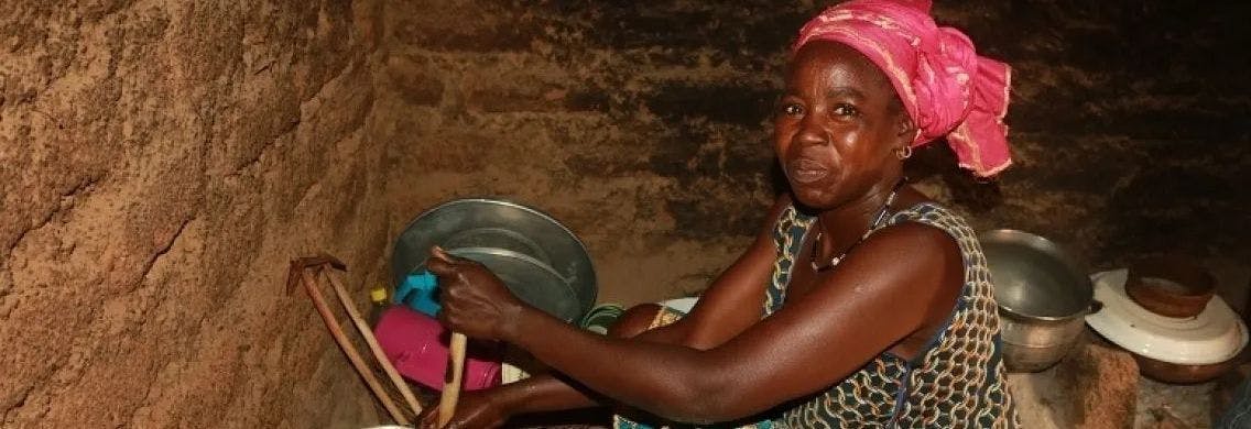 Woman cooks with a biodigester stove.